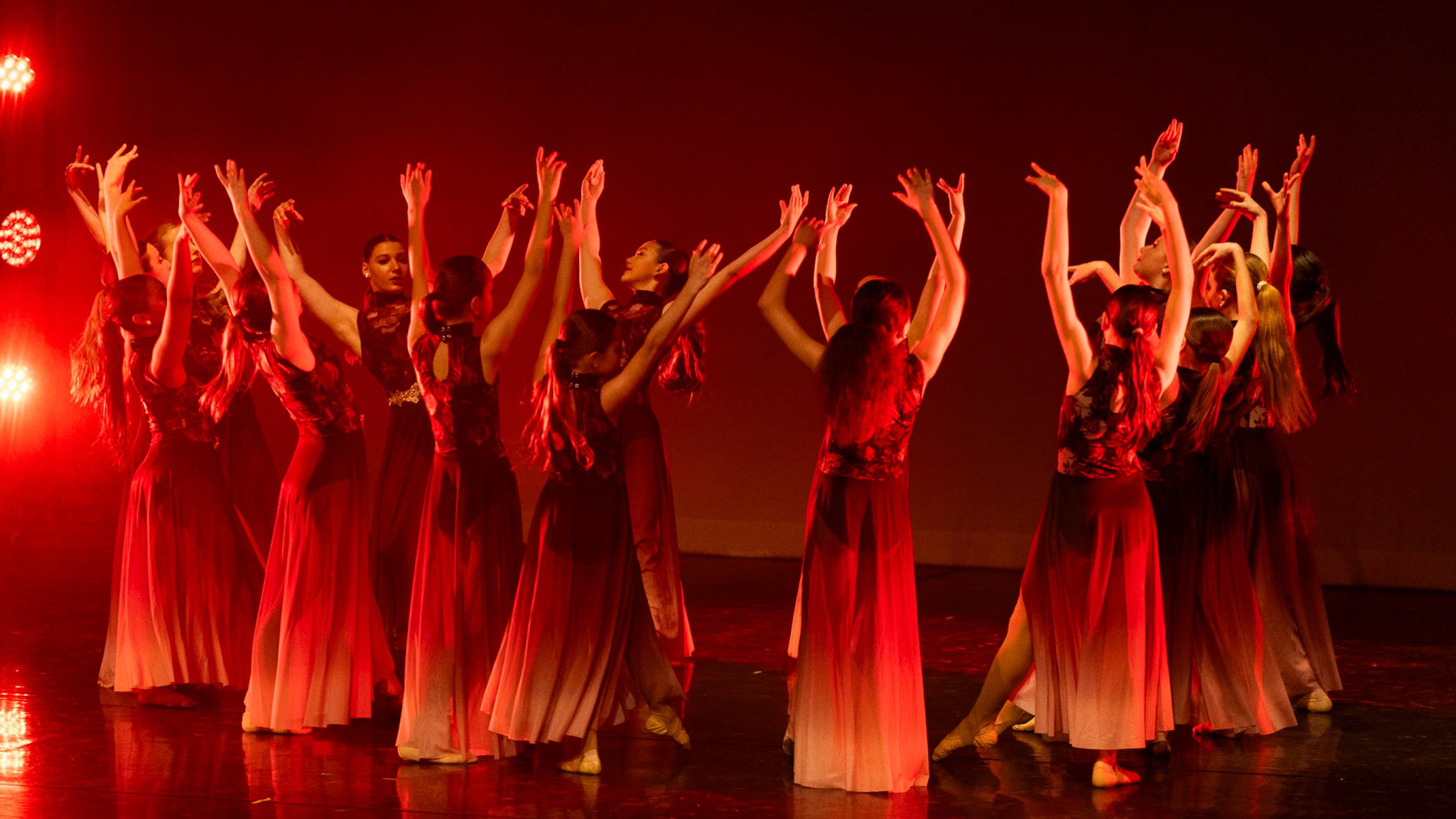 Dancers in a circle with red lighting