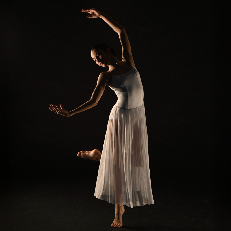dancer in white costume on black background